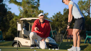 woman receiving golf lessons